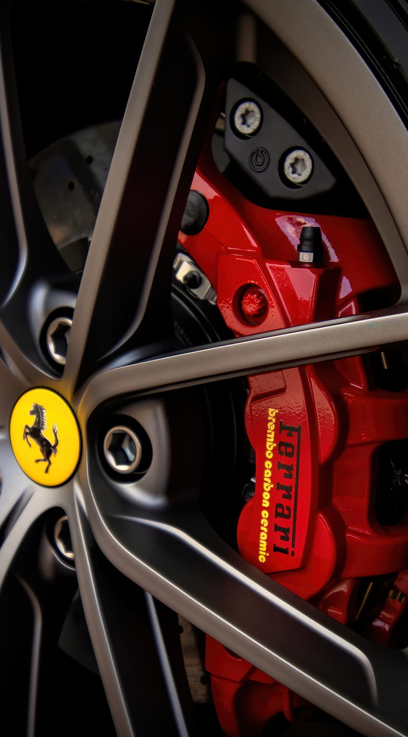 Close-up of a Ferrari alloy wheel with red Brembo carbon-ceramic brake caliper after a full wheel detail