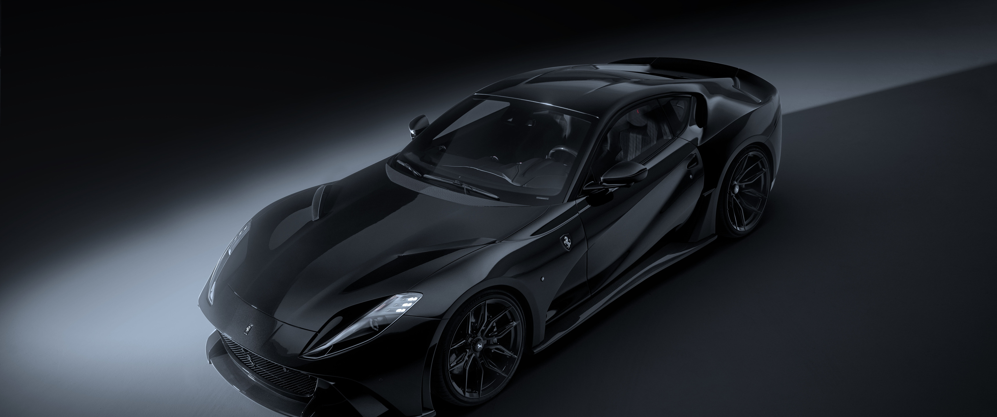 Black Ferrari 812 luxury coupe in a dark studio, polished to a mirror finish